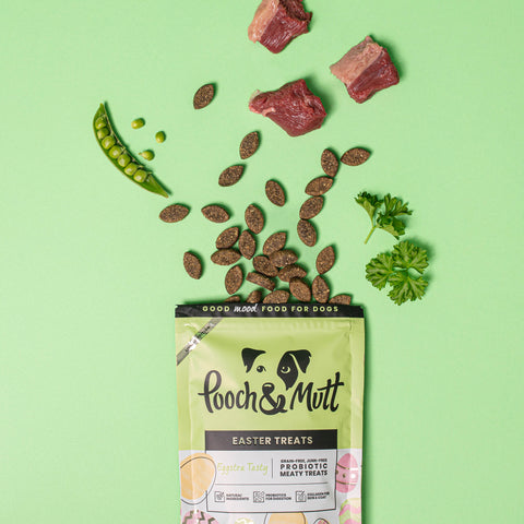 Pooch and mutt easter meaty treats packet with contents and raw ingredients spilling out